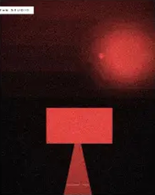 Red light and an angular sculptural form against a dark studio backdrop